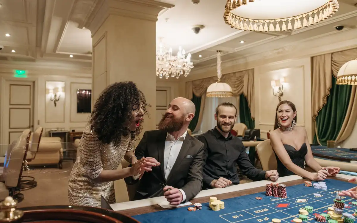 Friends celebrating a win together at a casino table – the PHFUN social gaming vibe