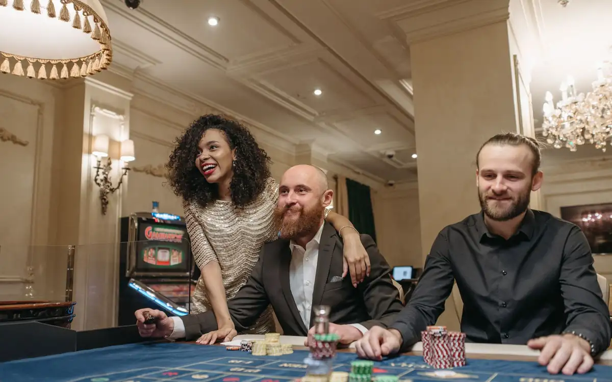 Smiling players gathered around a casino table at night – PHFUN players