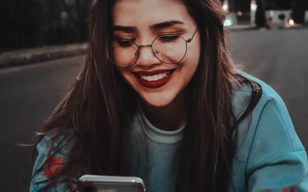 Smiling woman using her smartphone outdoors – PHFUN e-wallet cash-in