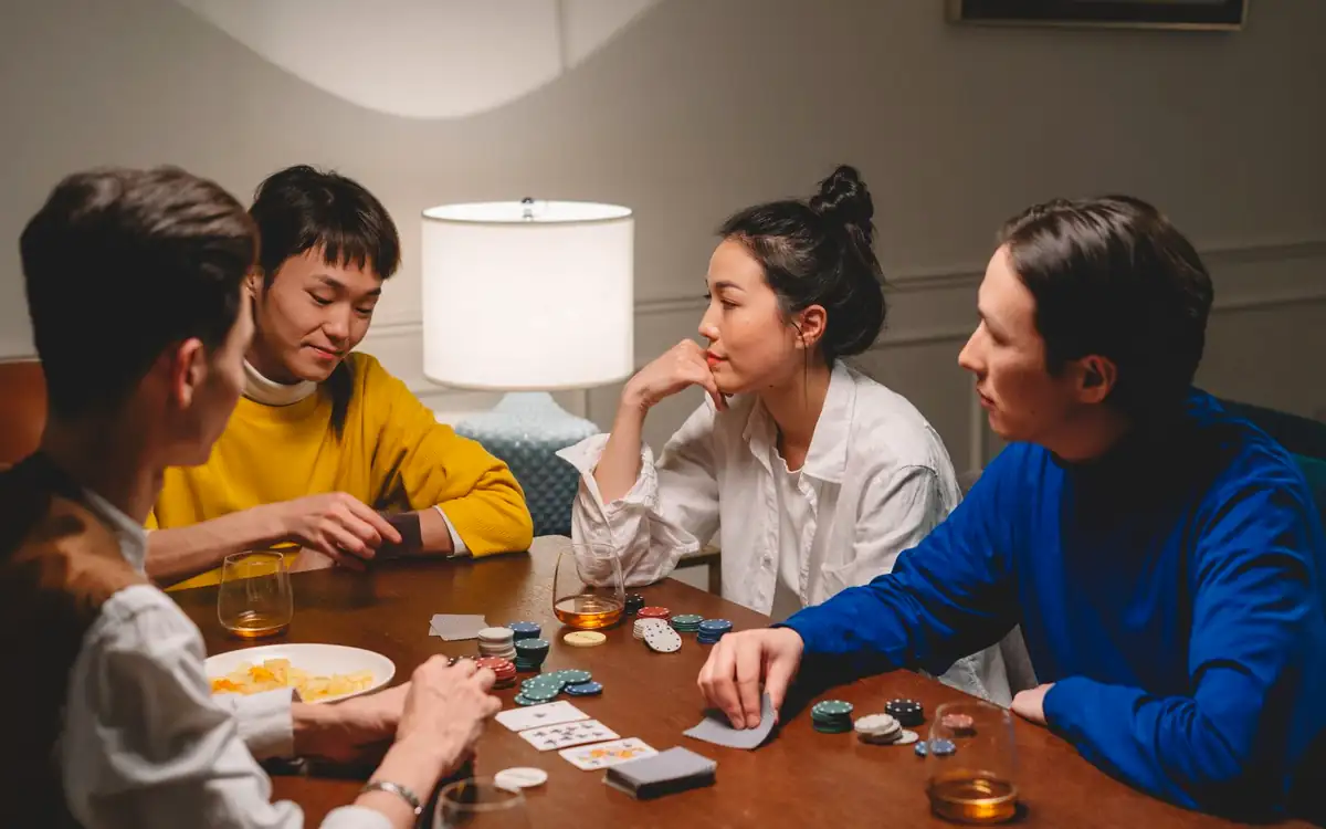 Group of Asian friends playing cards and chips at home – PHFUN card games