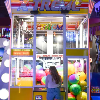 Plinko: player at a colourful arcade prize machine